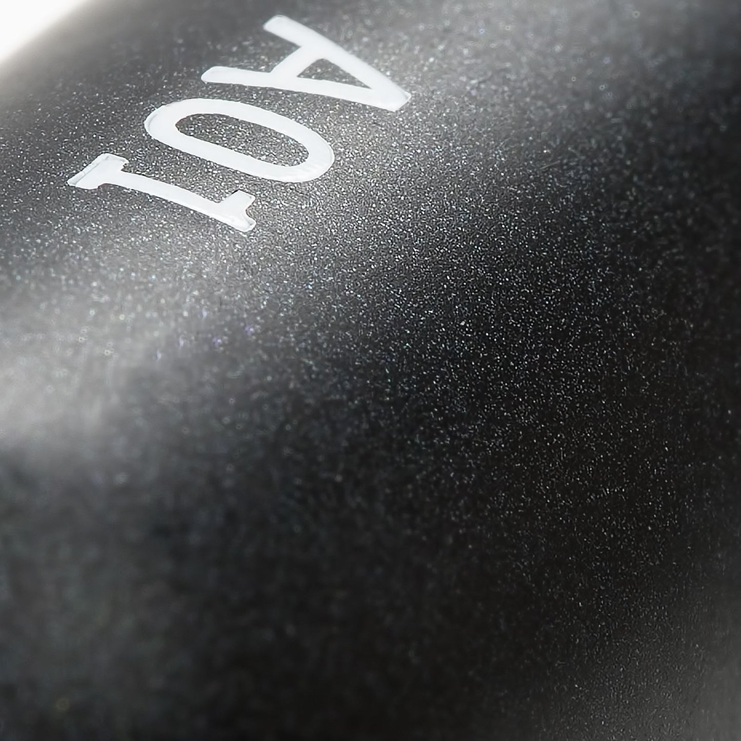 Close-up view of the "Flat Definer" makeup brush handle with a sleek pearl-coated finish and the number "A01" printed on it.